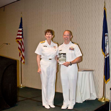 Presented to CDR Michael C. Elliot by VADM Tighe