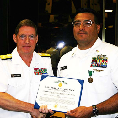 Presented to CTRCM(SW/AW) Anthony Perez by RADM Deets