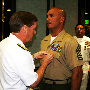 Presented to MSGT Miguel Rodriguez by RADM Deets