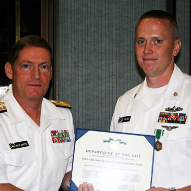 Presented to  CTMC(SW/AW) Jeffery M. Urness by RADM Deets